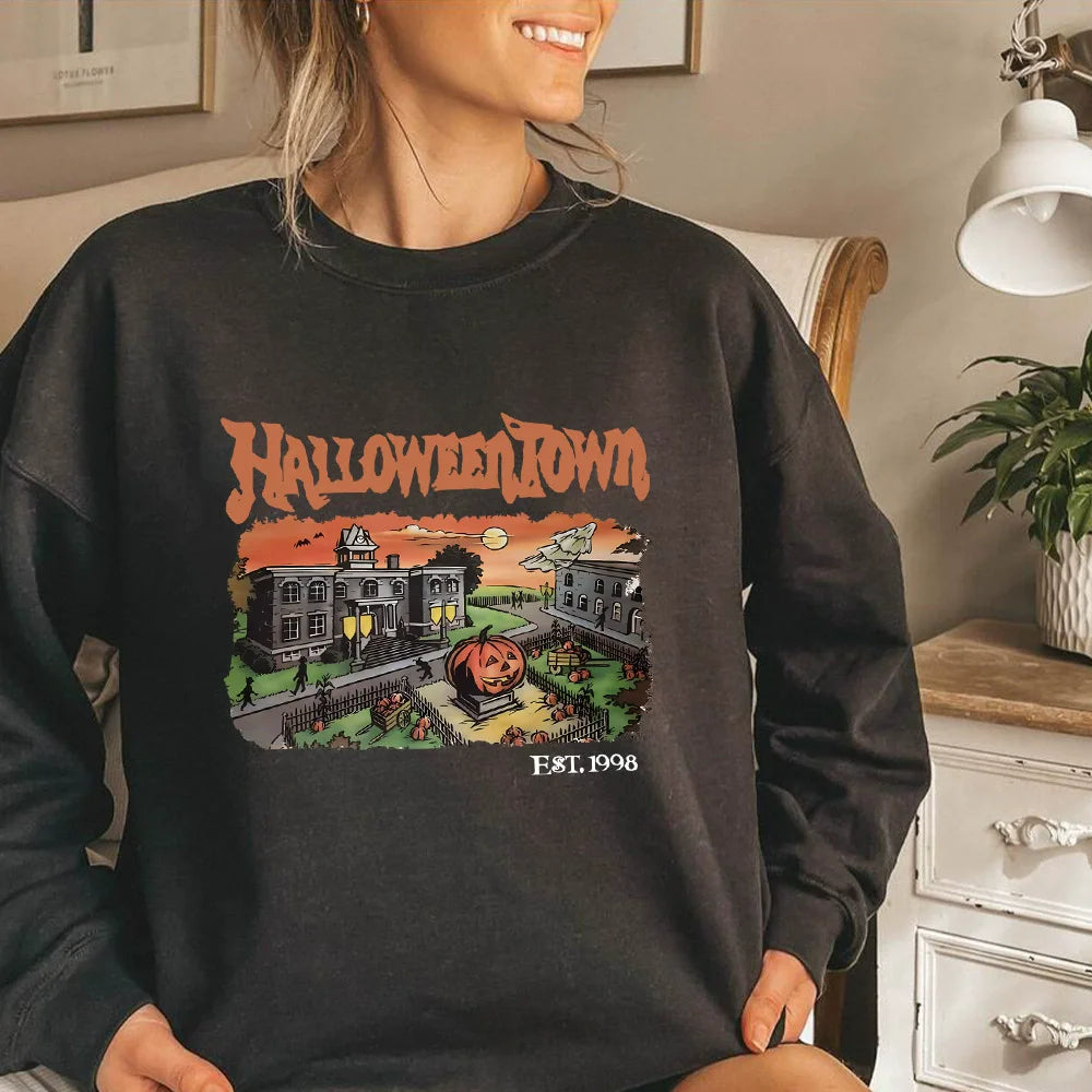 Person wearing a black 'Halloween Town' sweatshirt in a cozy indoor setting.